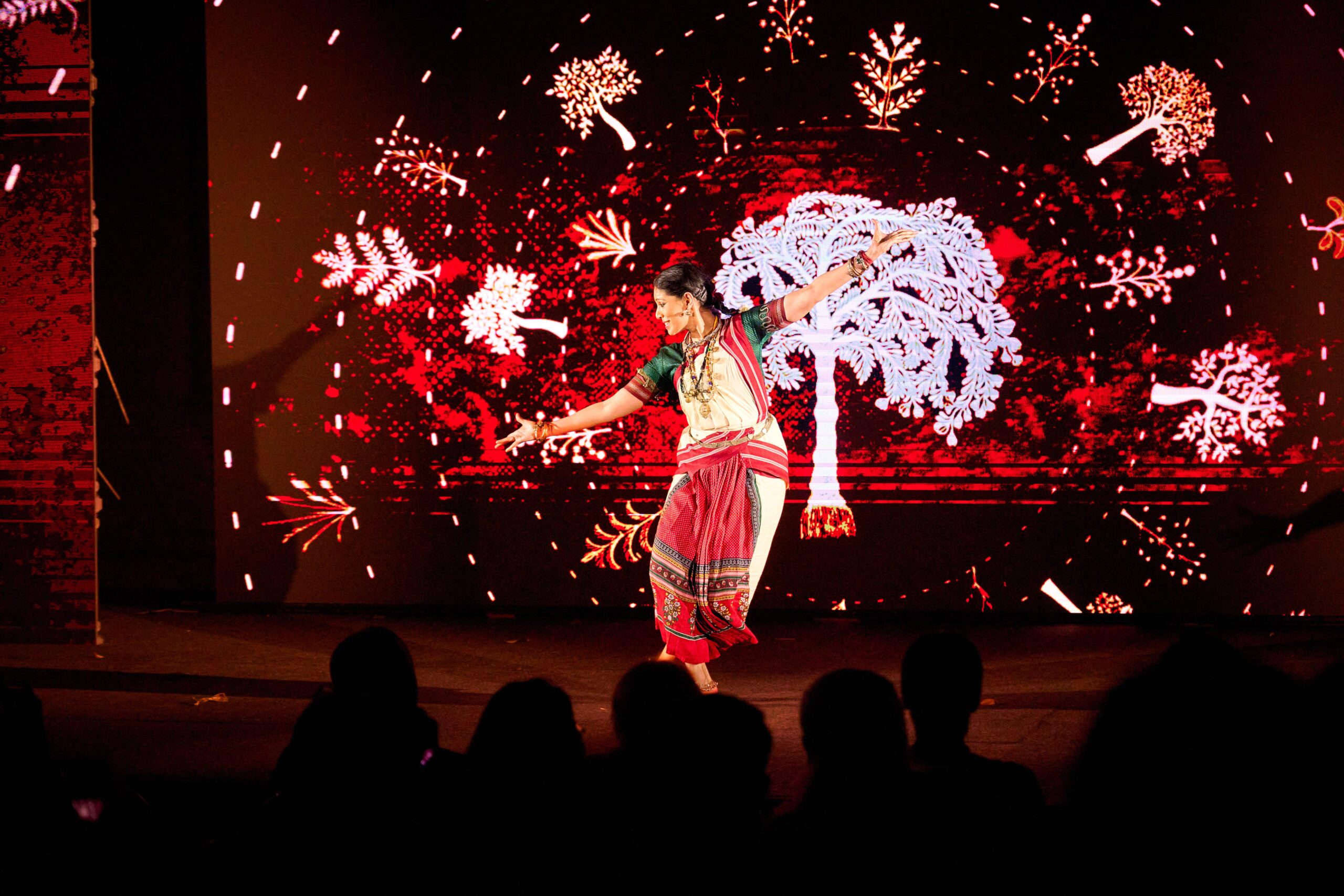 Traditional dance performance at BLR Echoes December 2024, featuring a vibrant background of artistic tree and floral motifs.